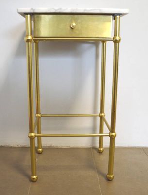 une table d'appoint avec un plateau en marbre blanc et doré et des pieds en laiton