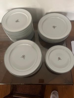 six plates sitting on a glass table with a pair of silver spoons
