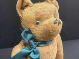 a brown teddy bear with a blue bow on it ' s neck