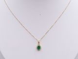 a gold necklace with a green stone pendant on a mannequin