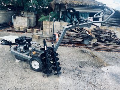 a machine that is sitting on the ground next to a pile of wood