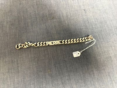 un bracelet en or sur lequel est gravé « here here »
