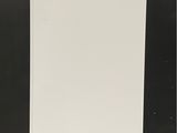 un réfrigérateur blanc posé sur une palette devant un mur noir