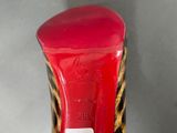 red and black high heeled shoe with a leopard print on the sole