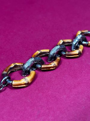 an image of a close up of a chain on a pink surface