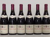 six bottles of wine are lined up on a table