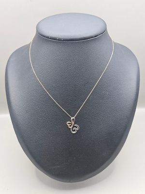 a silver necklace with a heart shaped pendant on a mannequin