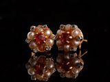 une paire de boucles d'oreilles en perles et rubis sur un fond noir