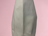 a green bag sitting on top of a pink surface
