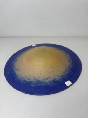a blue plate with a yellow center on a white surface