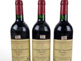 three bottles of red wine sitting next to each other on a white surface