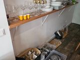 une cuisine avec beaucoup de vaisselle et de verres sur les étagères