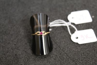 a black ring with a pink stone on it and a price tag