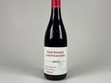une bouteille de vin rouge posée sur une table blanche