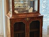 a wooden cabinet with a glass door and a clock on top of it