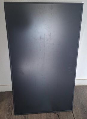 l'arrière d'un réfrigérateur noir posé sur un parquet