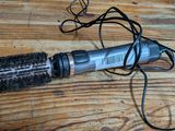 un sèche-cheveux et une brosse posés sur une table en bois