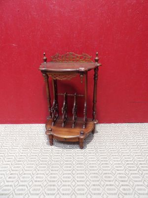 une petite table en bois avec un mur rouge en arrière-plan