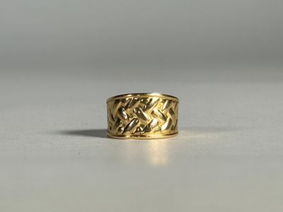 gros plan d'une bague en or sur une surface blanche