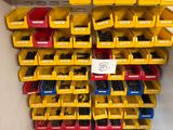 yellow and blue bins are stacked on the wall in a storage area