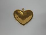 a gold heart shaped locke with a red stone in the center