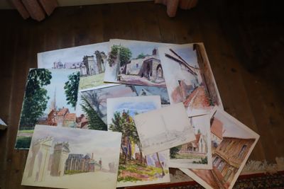 une pile de dessins posée par terre dans une pièce