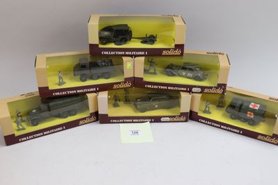 six petits trains miniatures emballés dans leurs boîtes, posés sur une surface blanche