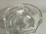 a glass bowl with a candle in it sitting on a table
