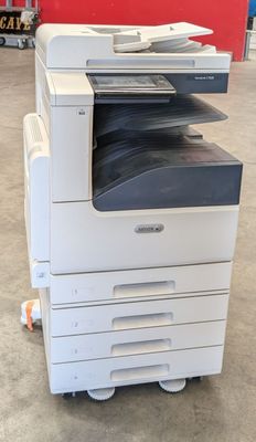 a white printer sitting on top of a cart in a warehouse