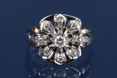 une image d'une bague ornée d'une fleur en diamant sur un fond bleu