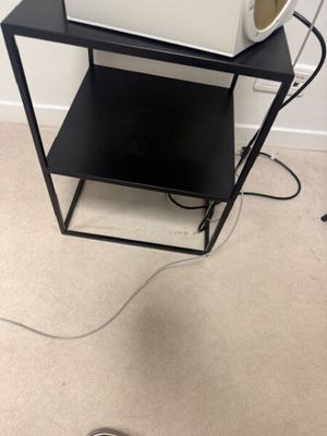 un micro-ondes posé sur une petite table noire