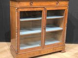 an old wooden display cabinet with glass doors and shelves