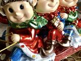 trois figurines d'elfes assis sur un traîneau