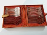 many forks and spoons in a wooden box on a table