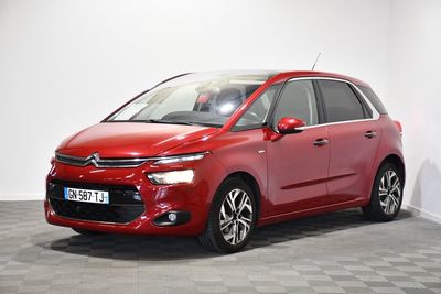 a red citrole is parked in a room with a checkered floor