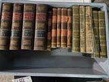 de nombreux livres anciens dans une boîte posée sur une table