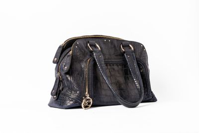 sac à main en cuir gaufré imitation crocodile noir sur fond blanc