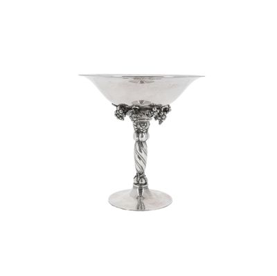 a silver wine glass with grapes on the stem