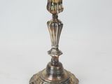 a silver candle holder on a white surface