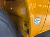 a close up of a yellow truck with a sticker on it ' s side