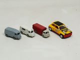 four toy cars sitting next to each other on a white surface
