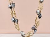a black and white pearl necklace on a gold chain