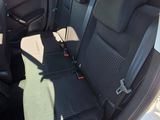 the back seats of a white car with a black seat belt