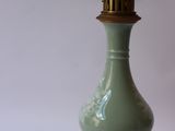a green vase with a gold base on a white background