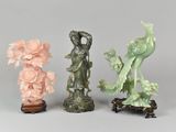 three different colored figurines of birds and flowers on a table