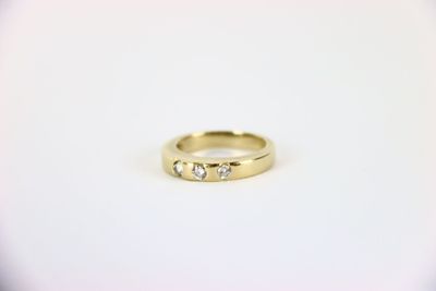 a close up of a gold ring with three diamonds on it