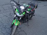 une moto verte et noire garée sur un parking