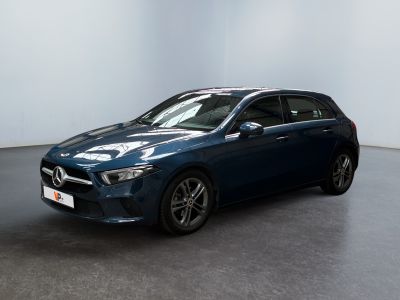 une Mercedes CLA bleue garée dans une pièce blanche
