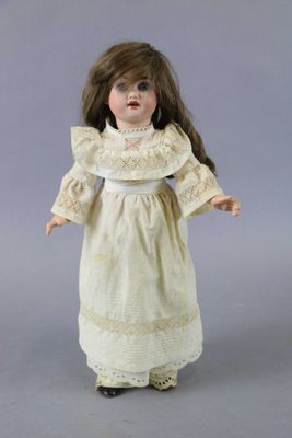 an image of a doll of a little girl in a white dress