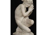 une image représentant une statue d'une femme agenouillée sur un socle en marbre